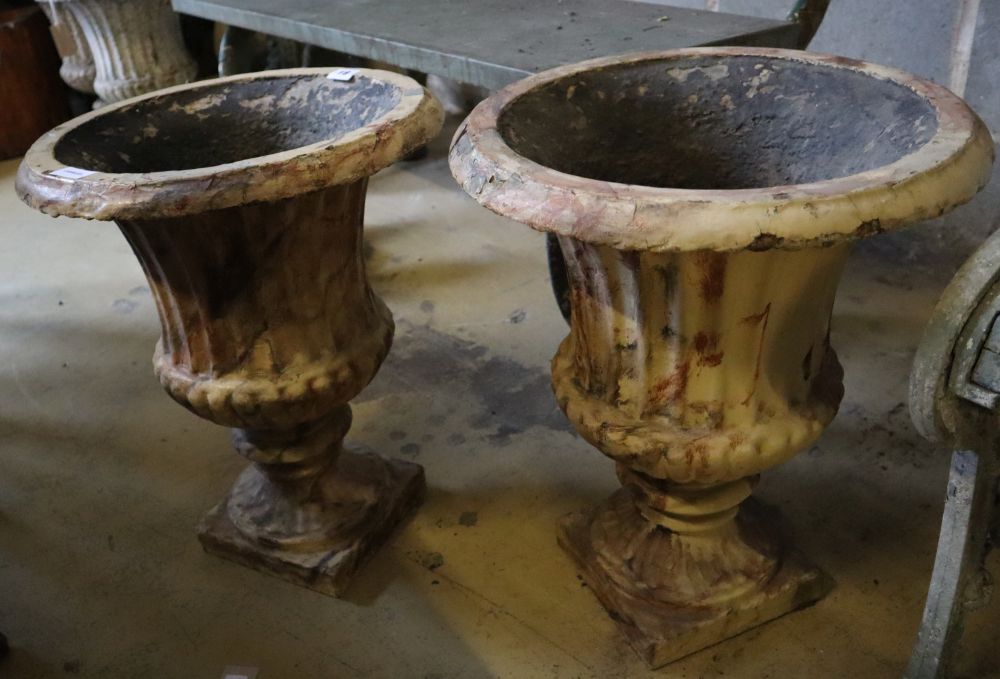 A pair of Victorian faux marble cast iron urn campana garden urns, 39cm diameter, height 46cm